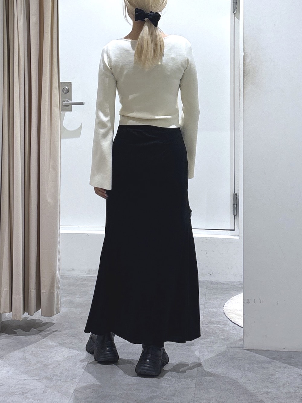 ホワイト系のニット/セーター、ブラック系のスカート、ブラック系のショルダーバッグを着用したレディースの冬コーディネートの4枚目の写真