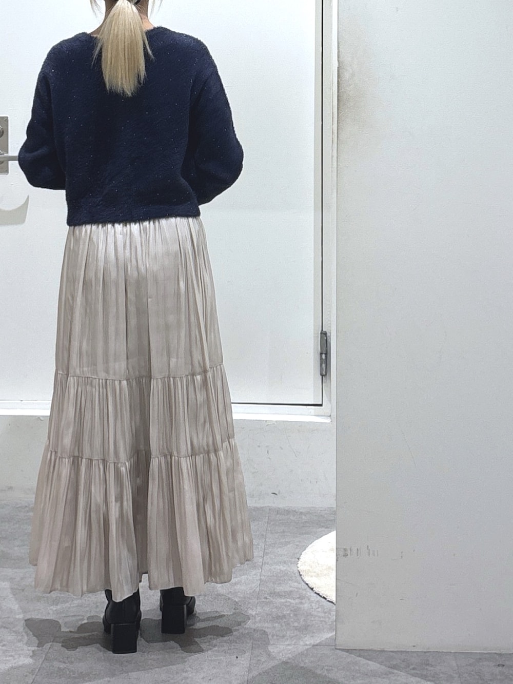 ブルー系のニット/セーター、ホワイト系のスカート、ブラウン系のショルダーバッグを着用したレディースの冬コーディネートの3枚目の写真