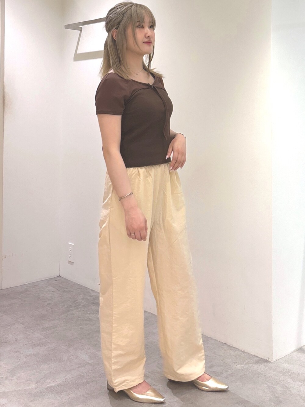 ブラウン系のTシャツ/カットソー、ベージュ系のショルダーバッグ、ゴールド系のパンプスを着用したレディースの夏コーディネートの3枚目の写真