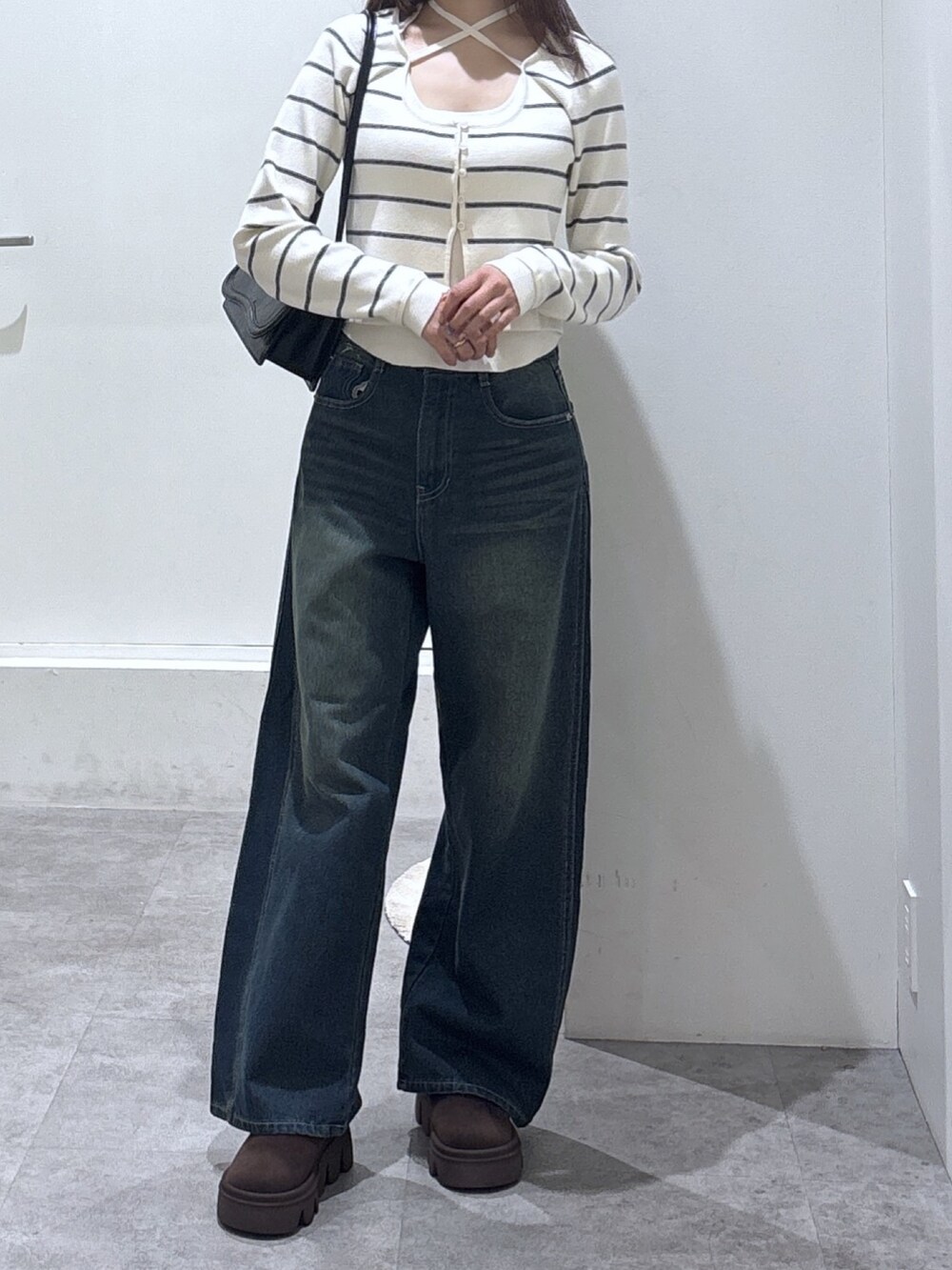 ブルー系のデニムパンツ、ホワイト系のニット/セーターを着用したレディースの冬コーディネートの2枚目の写真