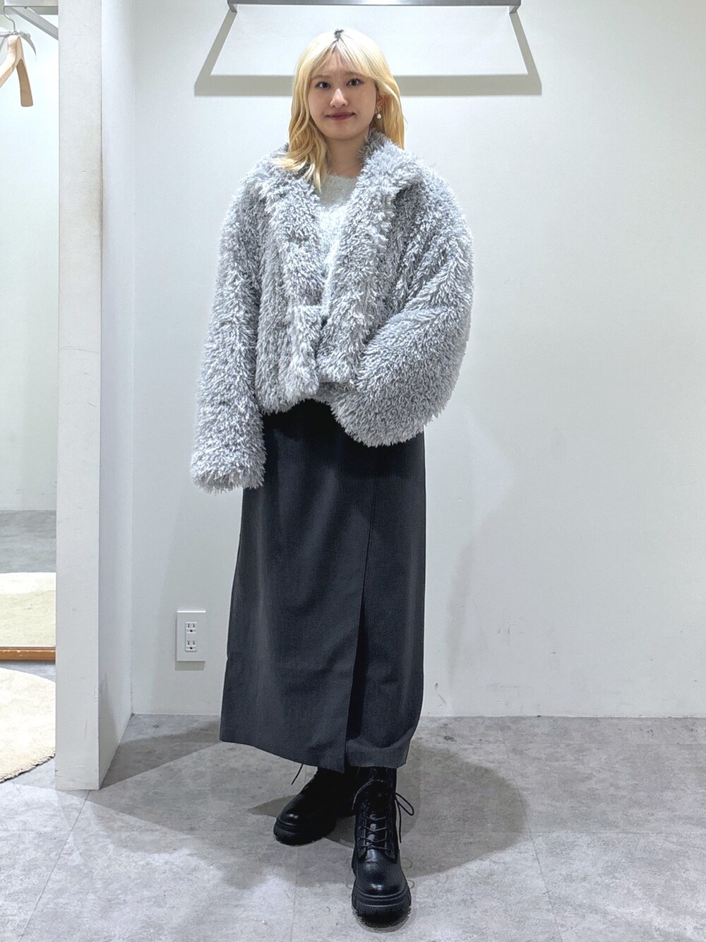 ホワイト系のニット/セーター、グレー系のスカート、シルバー系のトートバッグを着用したレディースの秋コーディネートの3枚目の写真