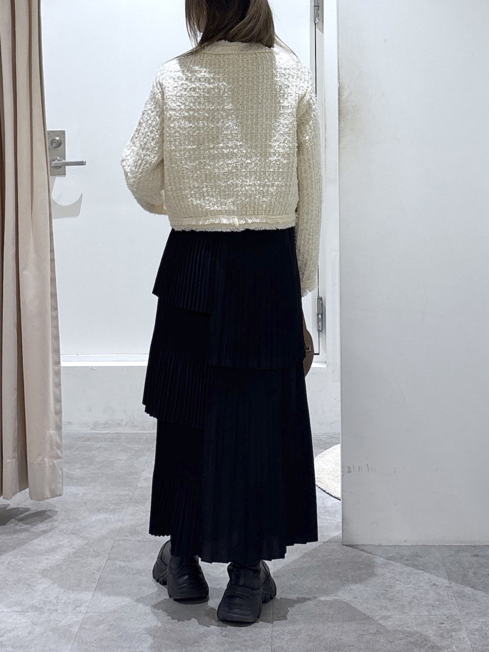 ホワイト系のニット/セーター、ブラウン系のショルダーバッグ、ブラック系のスカートを着用したレディースの冬コーディネートの3枚目の写真