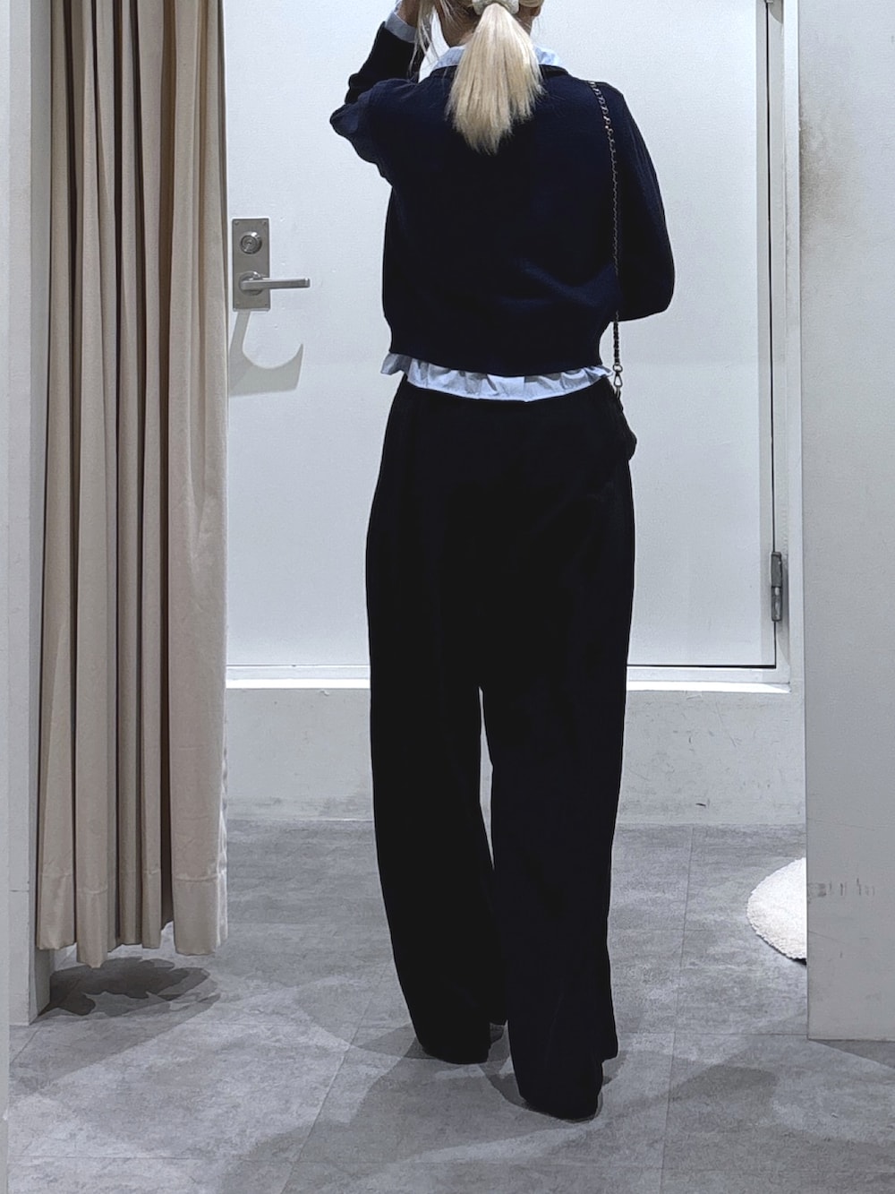 ブルー系のニット/セーター、ブラック系のスラックス、ブラック系のトートバッグを着用したレディースの冬コーディネートの3枚目の写真