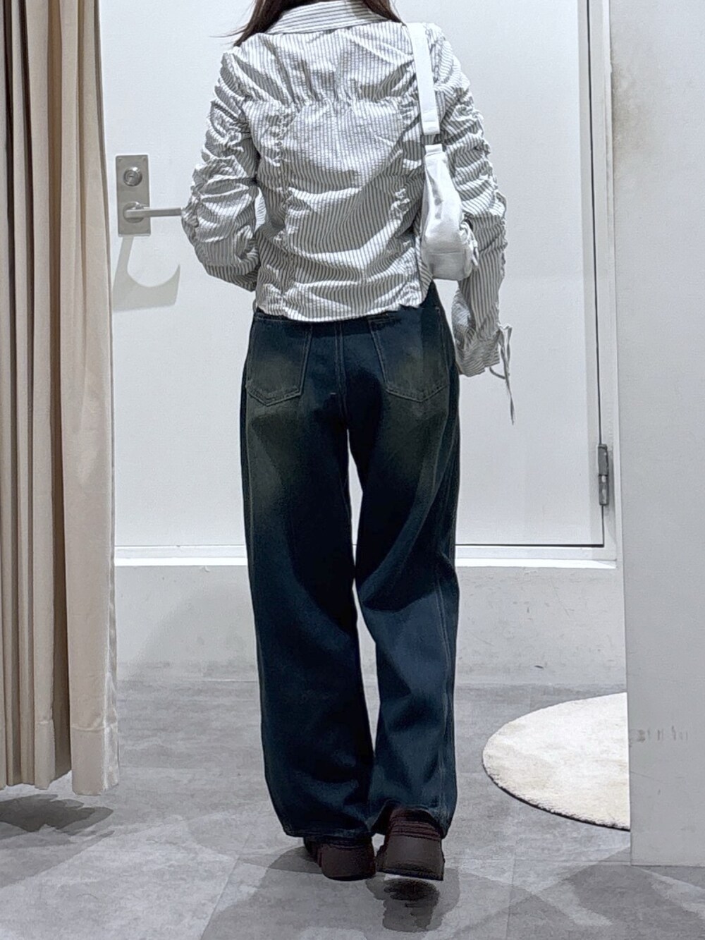 ホワイト系のシャツ/ブラウス、ブルー系のデニムパンツを着用したレディースの冬コーディネートの4枚目の写真