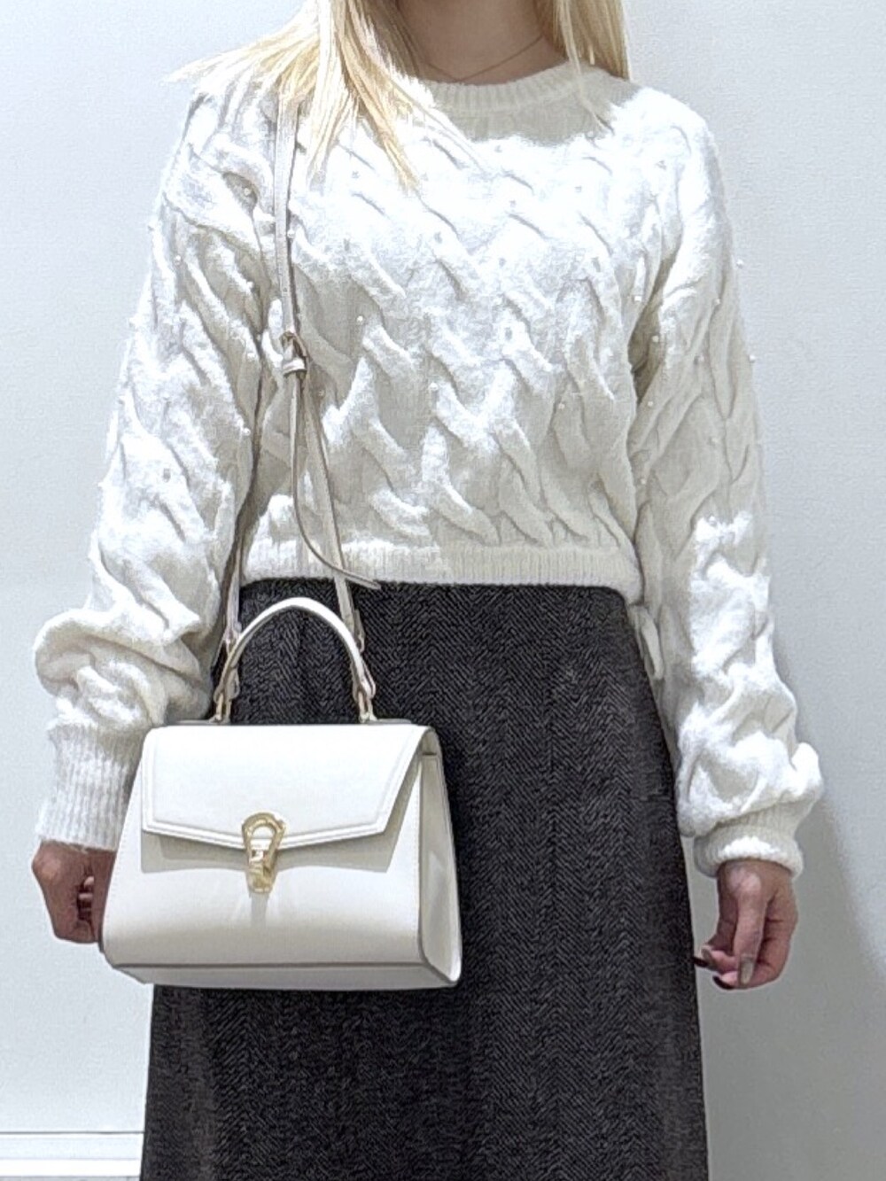 ホワイト系のニット/セーター、ブラウン系のスカートを着用したレディースの秋コーディネートの2枚目の写真