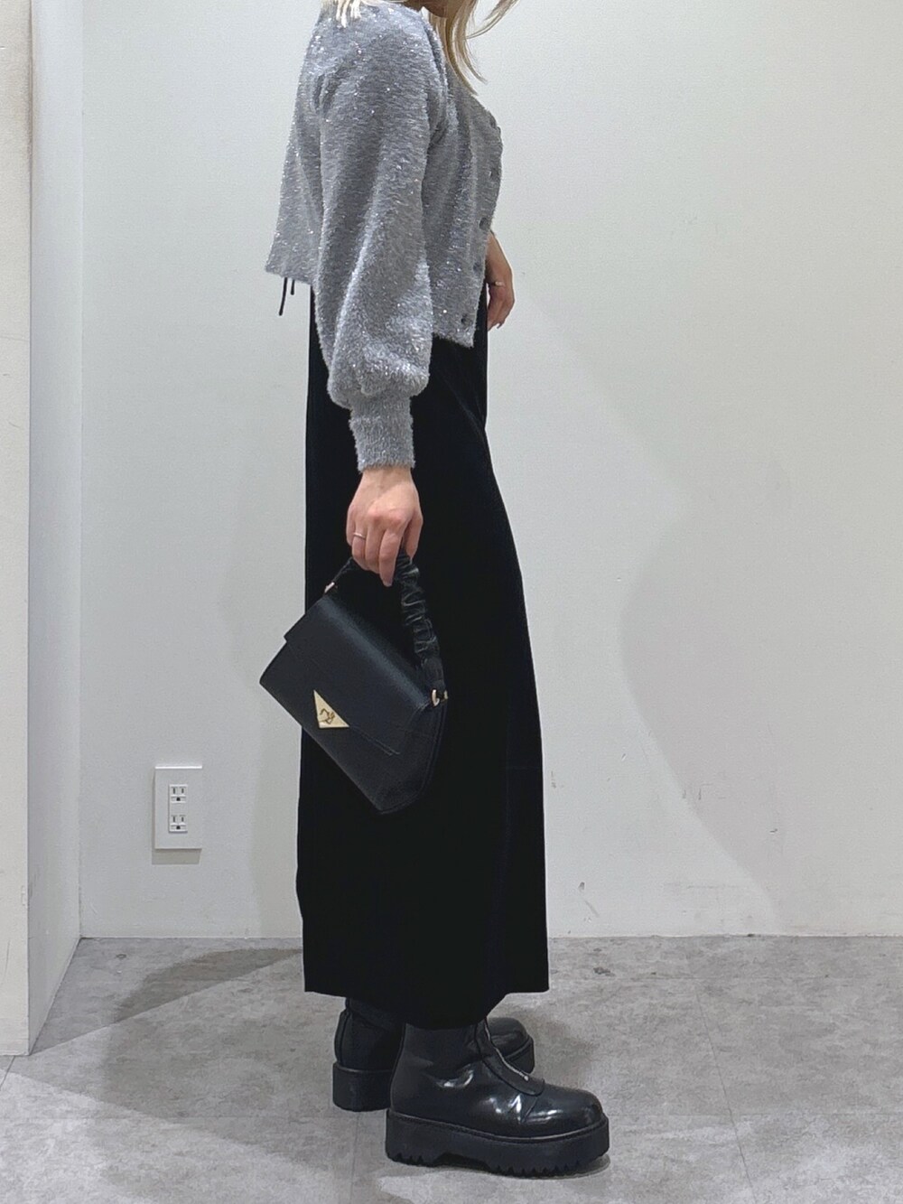 グレー系のカーディガン/ボレロ、ブラック系のワンピース、ブラック系のブーツを着用したレディースの秋コーディネートの4枚目の写真