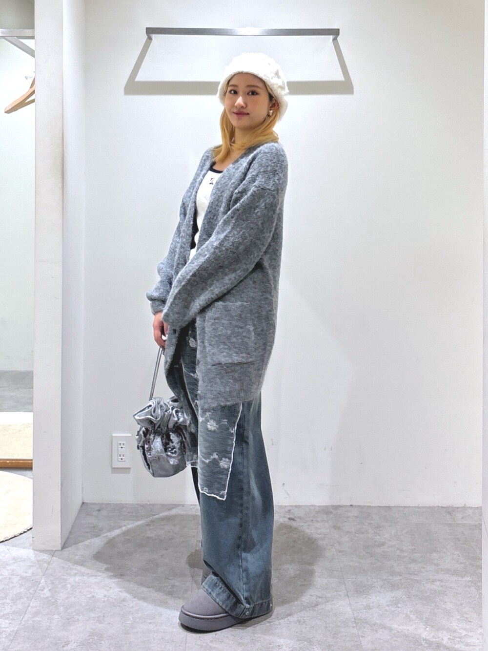 ブルー系のデニムパンツ、グレー系のブーツ、グレー系のハンドバッグを着用したレディースの秋コーディネートの2枚目の写真