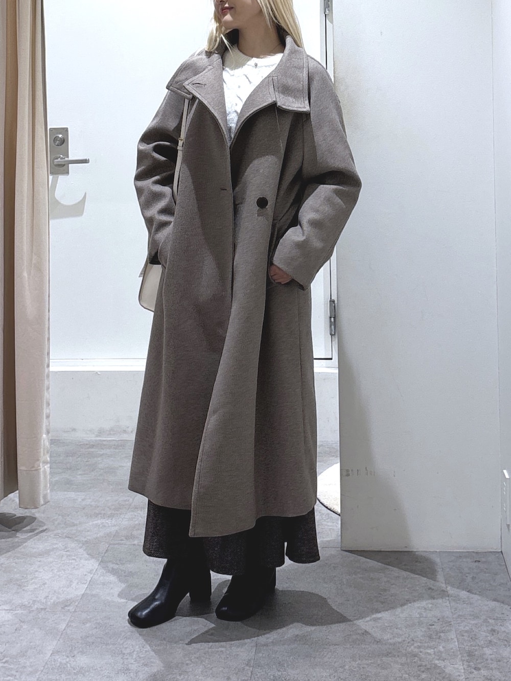 ホワイト系のニット/セーター、ブラウン系のスカート、ブラウン系のステンカラーコートを着用したレディースの秋コーディネートの3枚目の写真