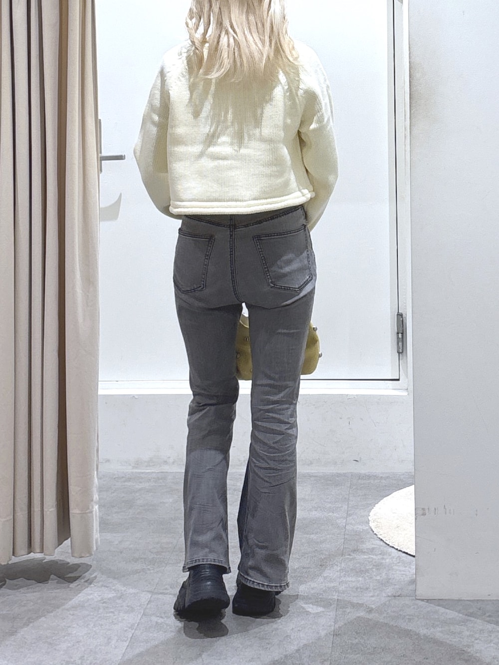 ホワイト系のカーディガン/ボレロ、ブラック系のデニムパンツを着用したレディースの秋コーディネートの2枚目の写真