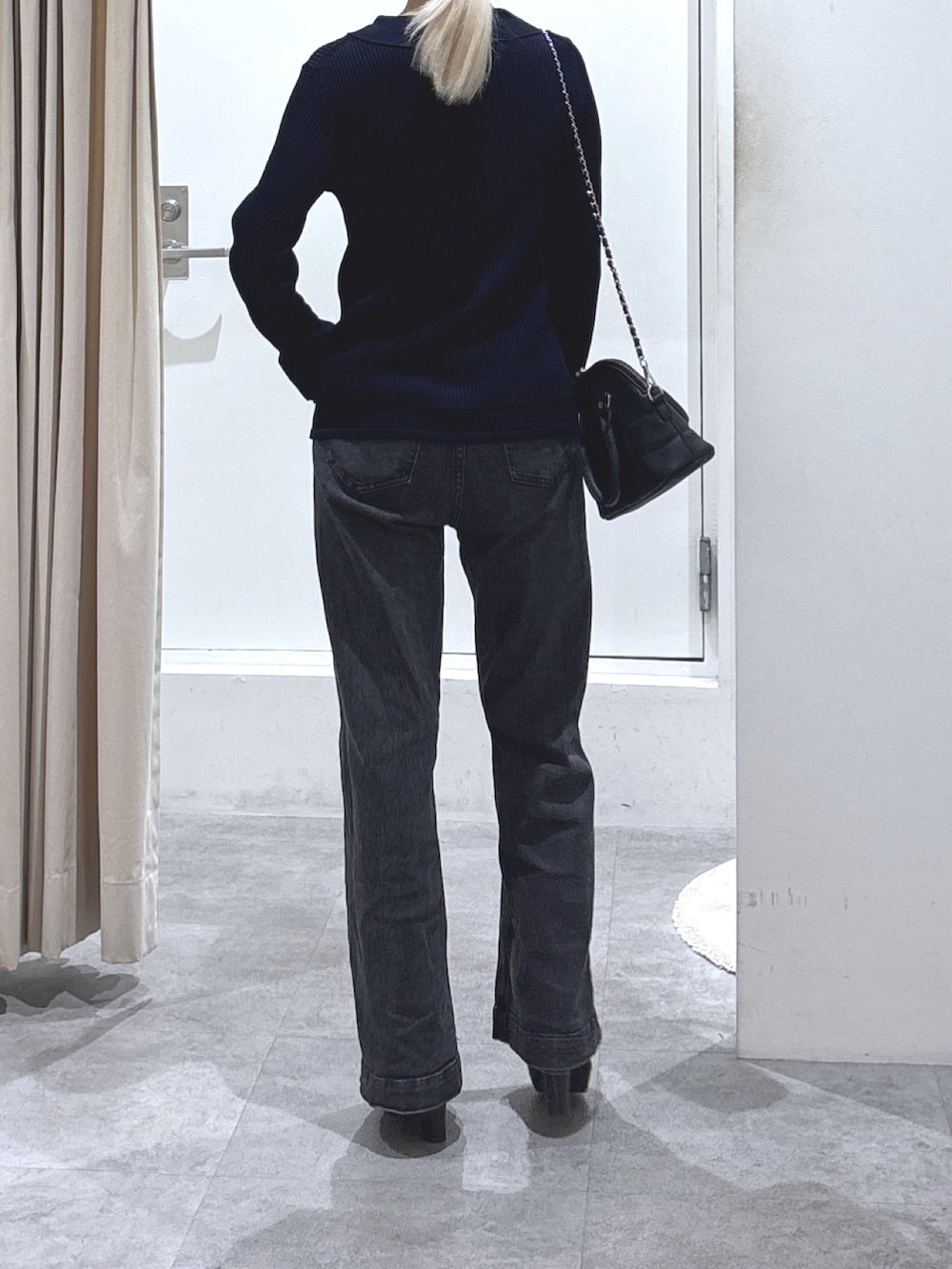 ブルー系のニット/セーター、ブラック系のデニムパンツ、ブラック系のトートバッグを着用したレディースの秋コーディネートの3枚目の写真