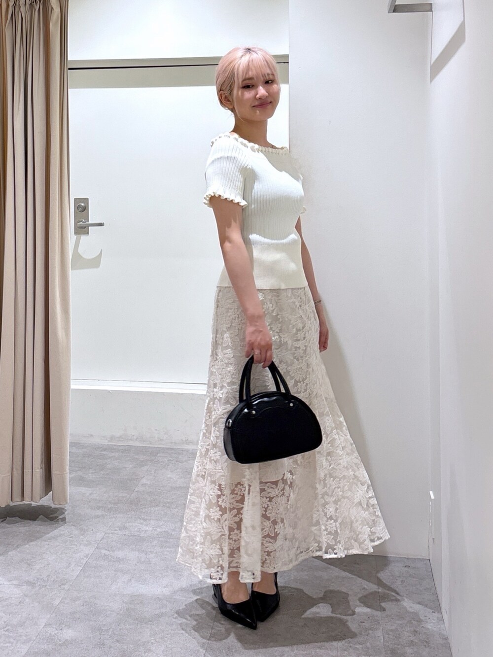 ホワイト系のニット/セーター、ホワイト系のスカートを着用したレディースの夏コーディネートの2枚目の写真