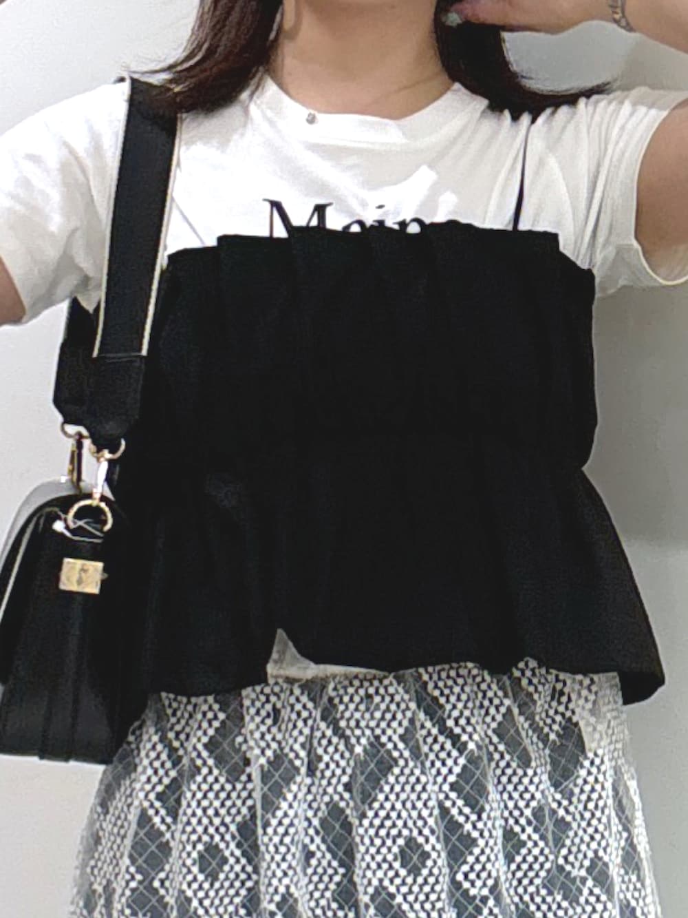 ブラック系のショルダーバッグ、ブラック系のシャツ/ブラウス、ブルー系のデニムパンツを着用したレディースの夏コーディネートの3枚目の写真
