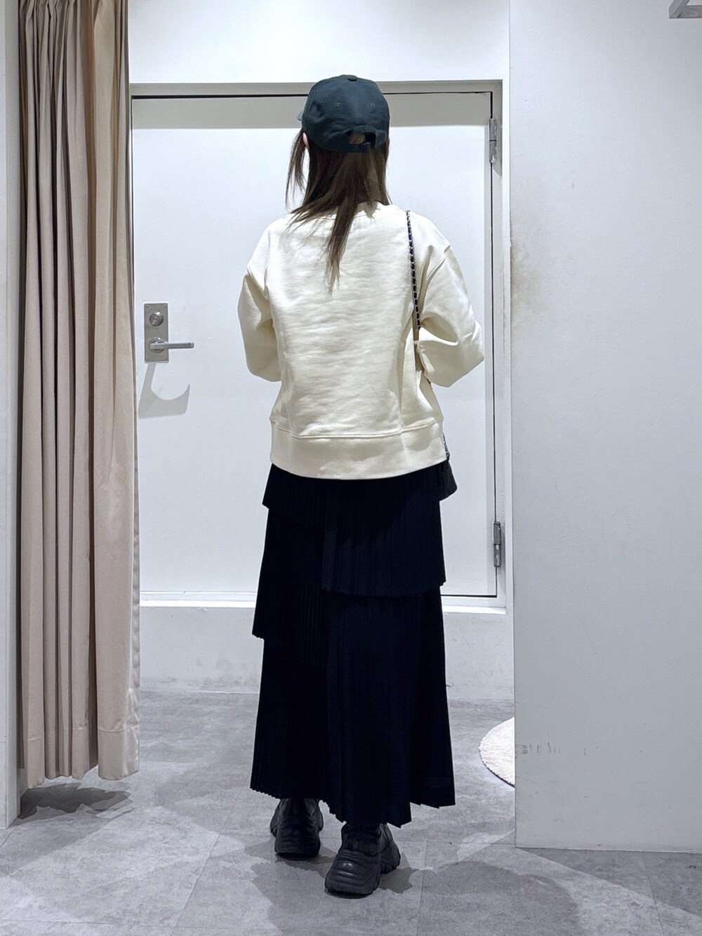 ホワイト系のスウェット、ブラック系のスカート、ブラック系のトートバッグを着用したレディースの冬コーディネートの3枚目の写真