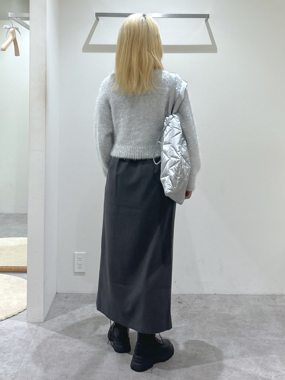 ホワイト系のニット/セーター、グレー系のスカート、シルバー系のトートバッグを着用したレディースの秋コーディネートの2枚目の写真