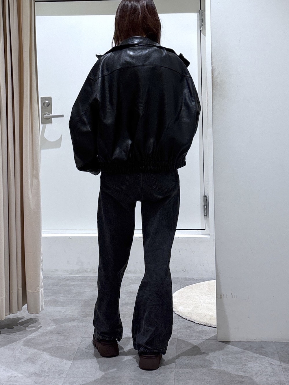 ブルー系のニット/セーター、ブラック系のブルゾン、ブラック系のデニムパンツを着用したレディースの冬コーディネートの3枚目の写真