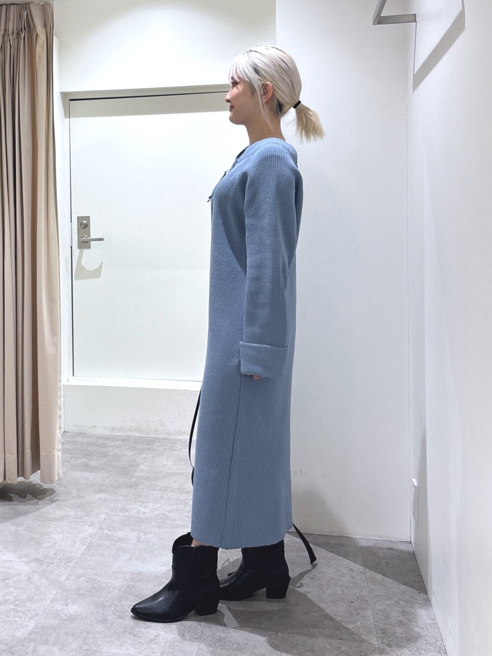 ブルー系のワンピース、ブラック系のブーツを着用したレディースの冬コーディネートの2枚目の写真