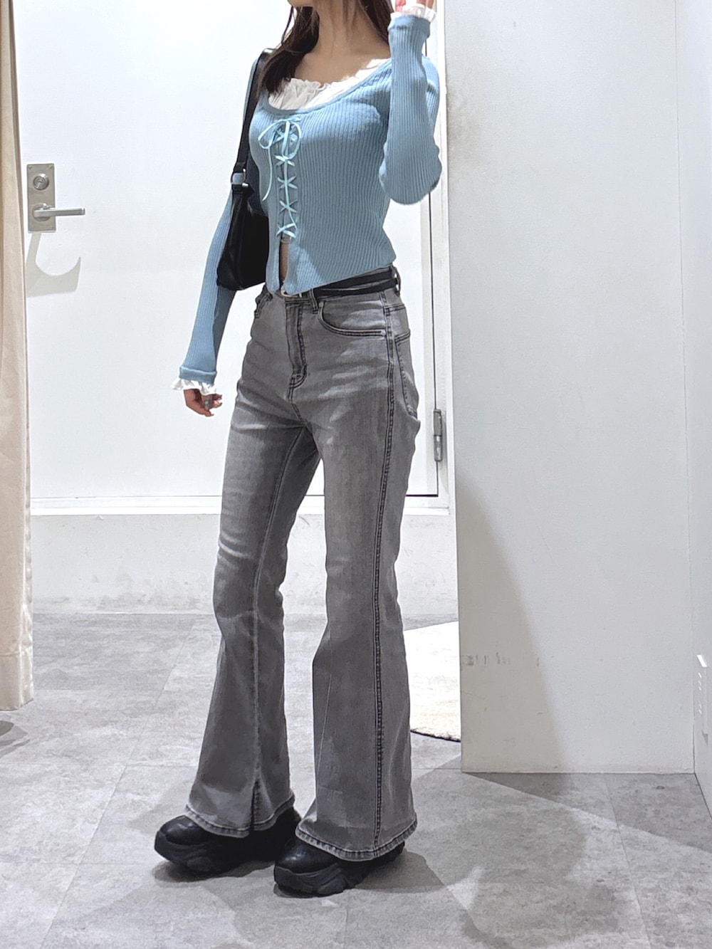 ブルー系のニット/セーター、ブラック系のデニムパンツを着用したレディースの冬コーディネートの3枚目の写真