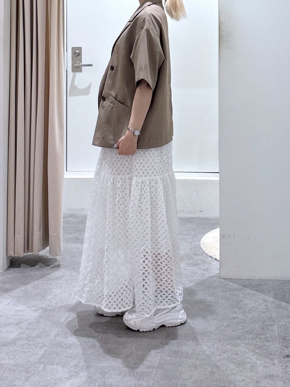 ホワイト系のワンピース、ブラウン系のテーラードジャケットを着用したレディースの夏コーディネートの2枚目の写真