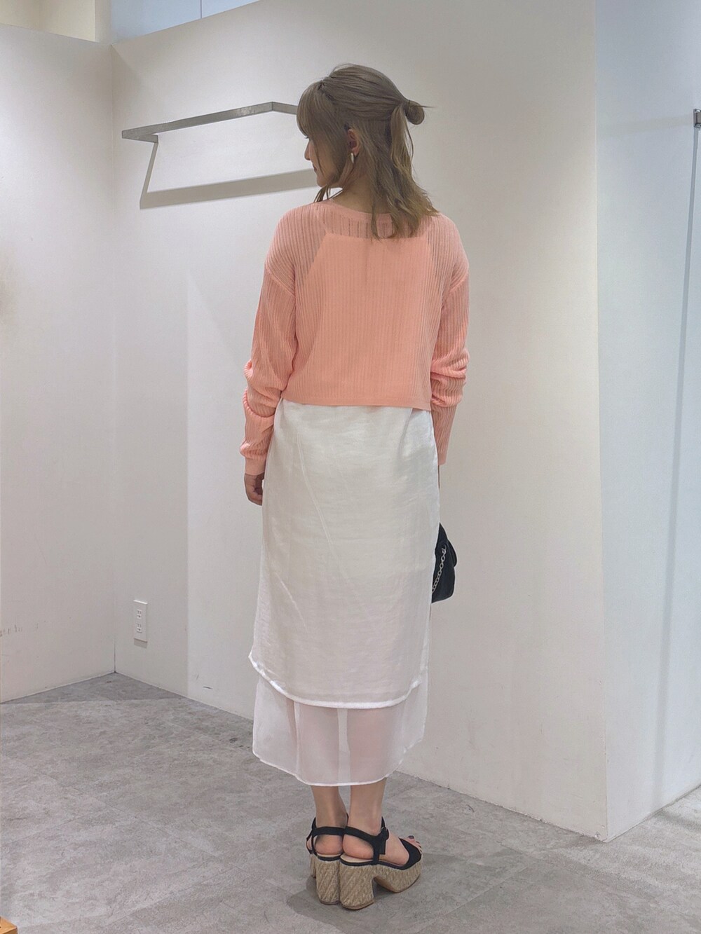 ピンク系のカーディガン/ボレロ、ホワイト系のワンピース、ブラック系のショルダーバッグを着用したレディースの夏コーディネートの4枚目の写真