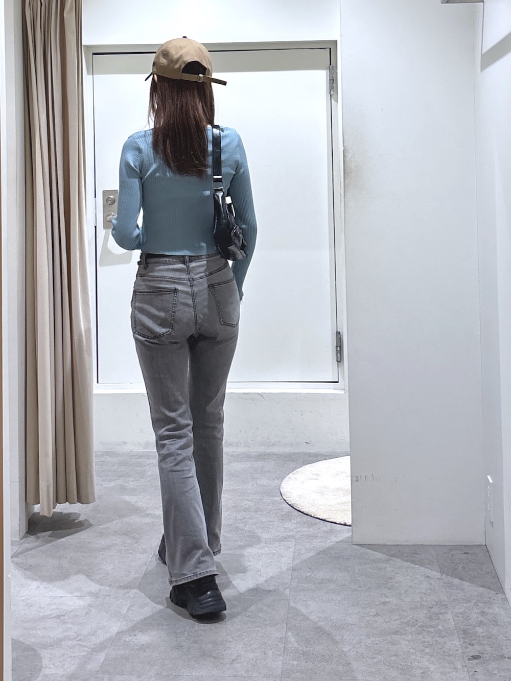 ブルー系のニット/セーター、ブラック系のデニムパンツを着用したレディースの冬コーディネートの4枚目の写真