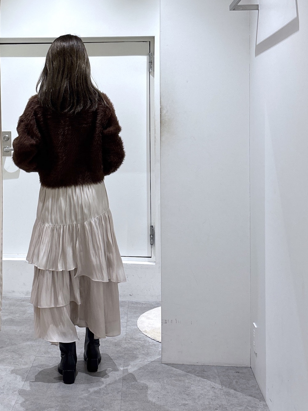 ブラウン系のニット/セーター、ブラック系のブーツ、ブラック系のトートバッグを着用したレディースの冬コーディネートの3枚目の写真