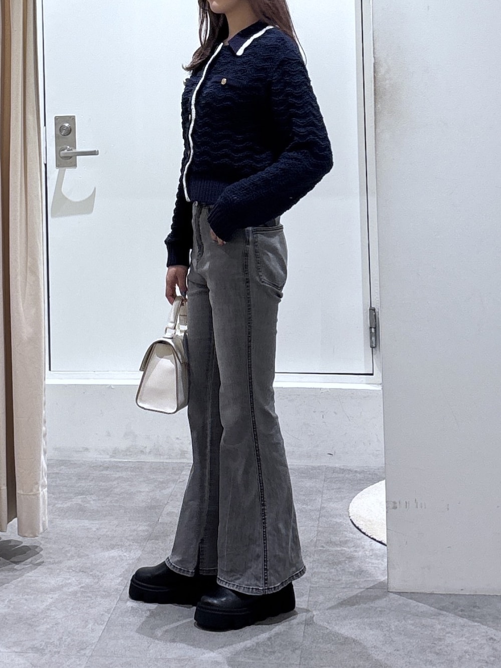 ブルー系のニット/セーター、ブラック系のデニムパンツを着用したレディースの冬コーディネートの3枚目の写真