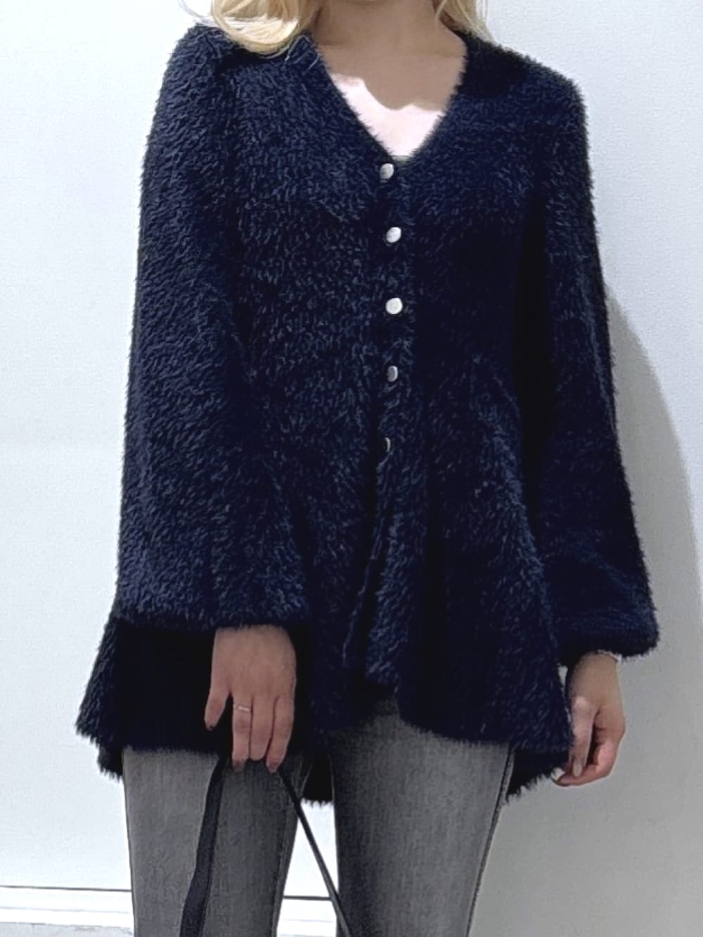 ブルー系のニット/セーター、ブラック系のデニムパンツを着用したレディースの秋コーディネートの2枚目の写真