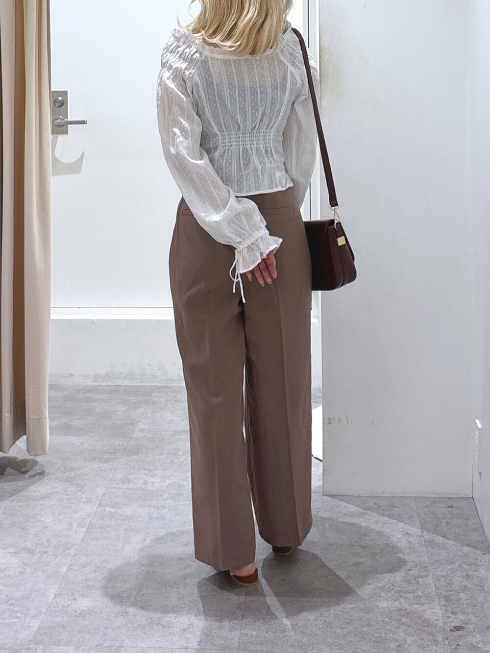 ホワイト系のシャツ/ブラウス、ブラウン系のスラックス、ブラウン系のサンダルを着用したレディースの夏コーディネートの2枚目の写真