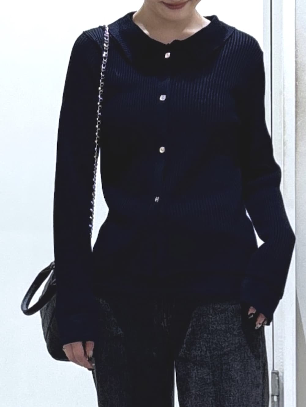 ブルー系のニット/セーター、ブラック系のデニムパンツ、ブラック系のトートバッグを着用したレディースの秋コーディネートの2枚目の写真