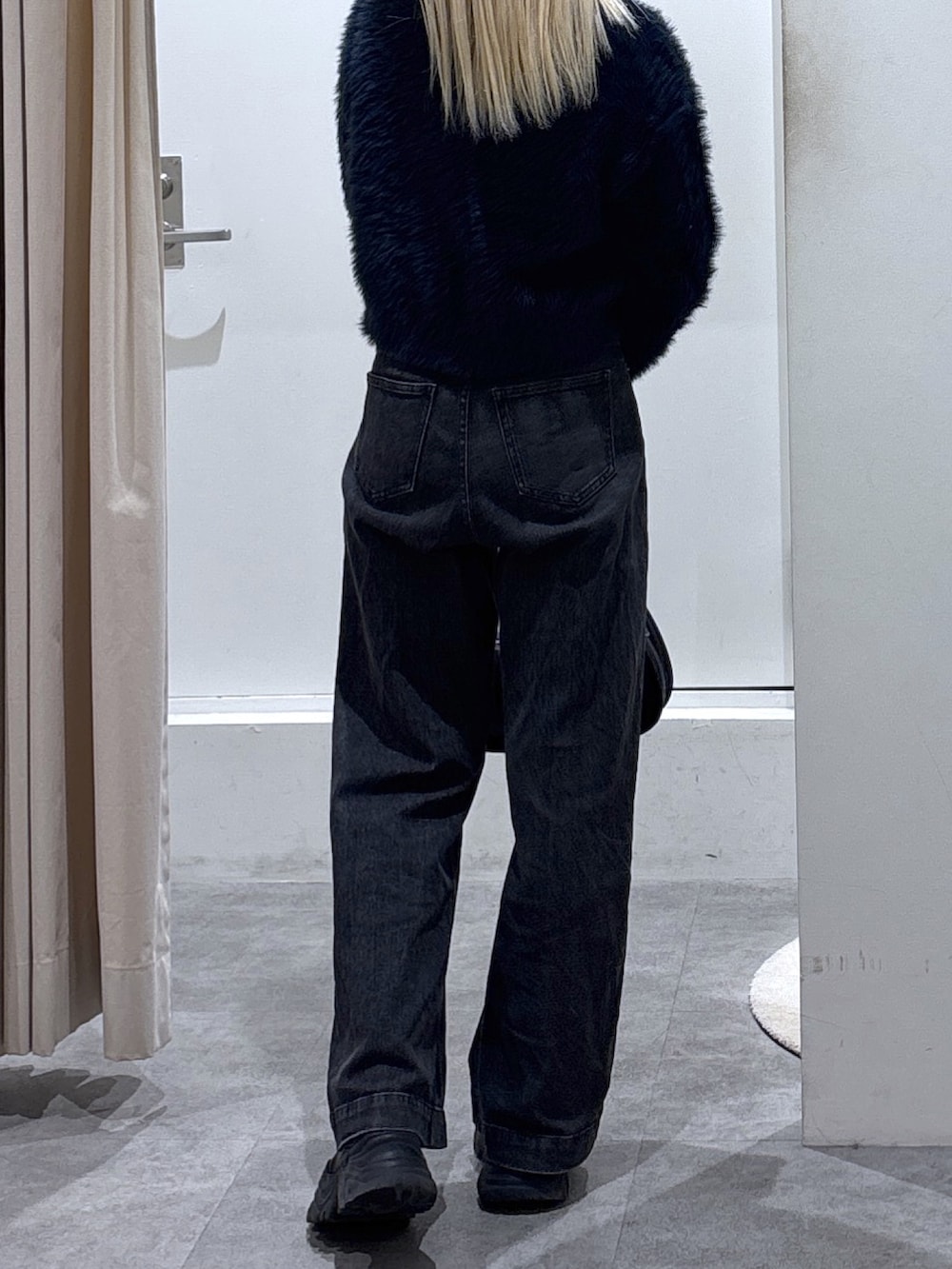 ブルー系のニット/セーター、ブラック系のデニムパンツを着用したレディースの秋コーディネートの4枚目の写真