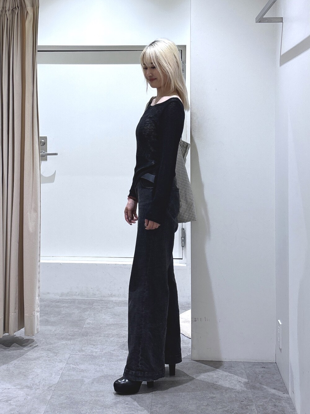 ブラック系のTシャツ/カットソー、ブラック系のデニムパンツ、ブラック系のブーツを着用したレディースの秋コーディネートの2枚目の写真