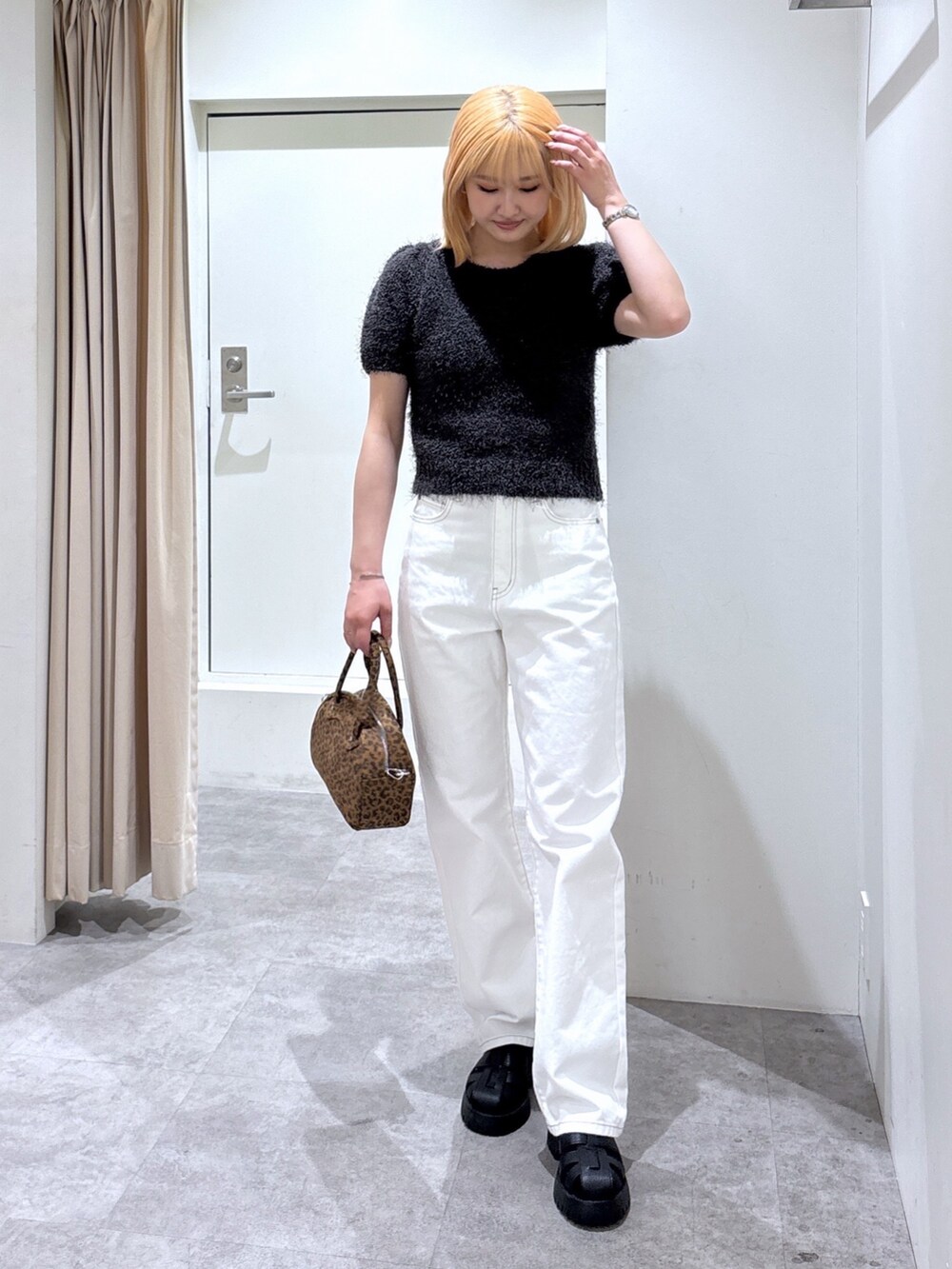 ホワイト系のデニムパンツ、グレー系のニット/セーターを着用したレディースの春コーディネートの2枚目の写真