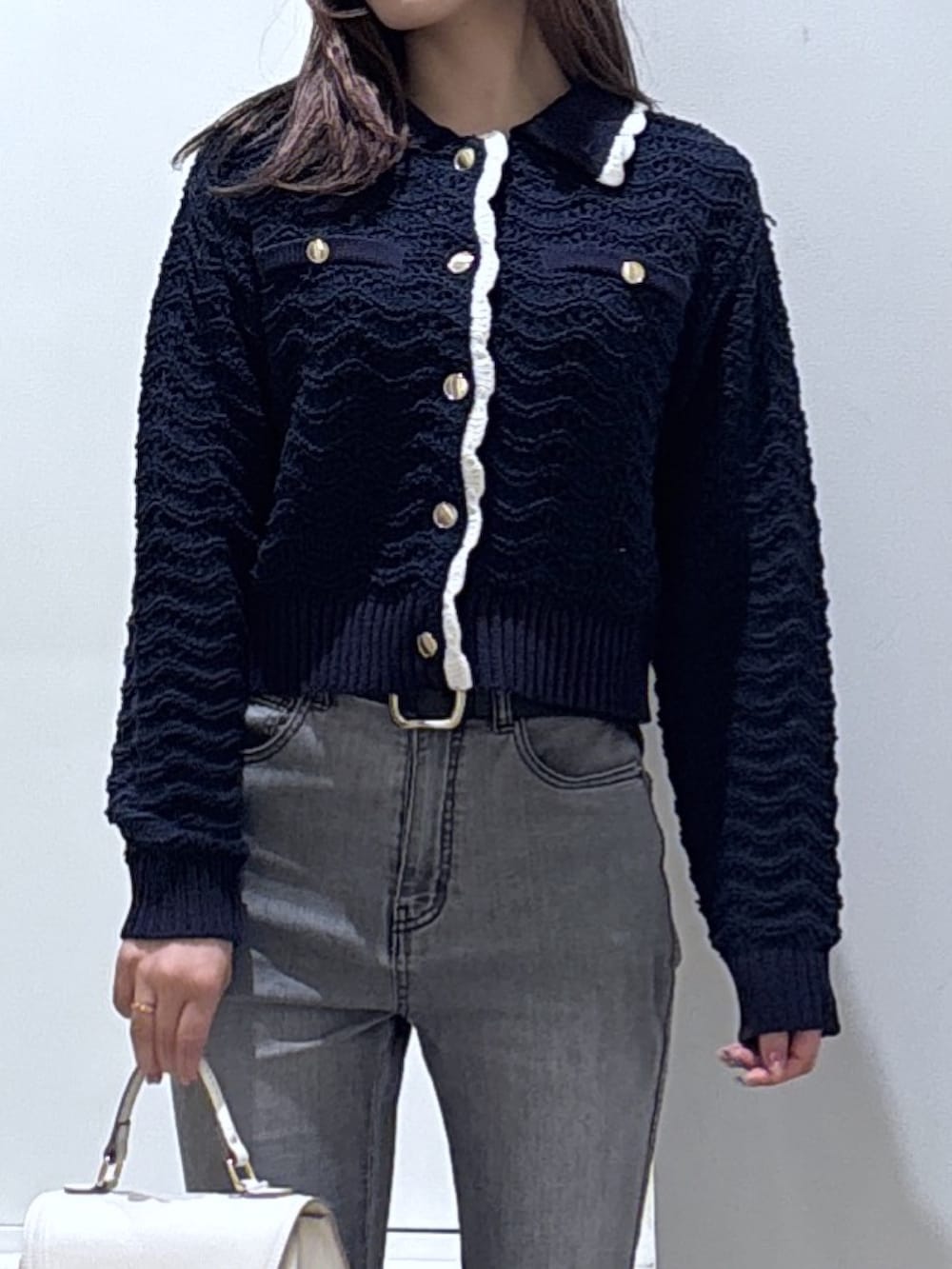 ブルー系のニット/セーター、ブラック系のデニムパンツを着用したレディースの冬コーディネートの2枚目の写真