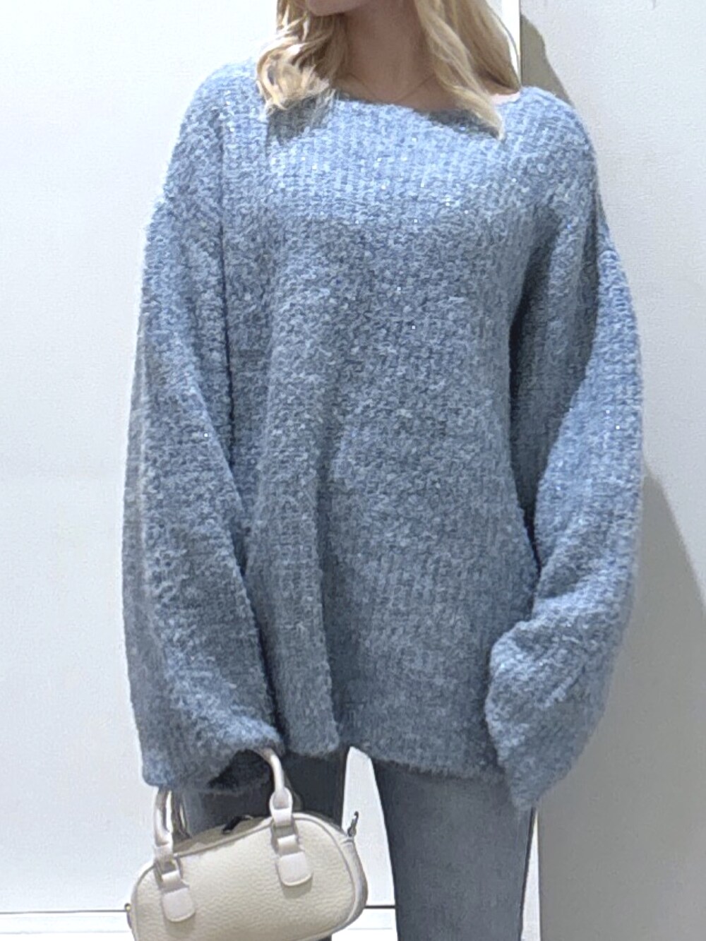 ブルー系のニット/セーター、ブルー系のデニムパンツを着用したレディースの秋コーディネートの2枚目の写真