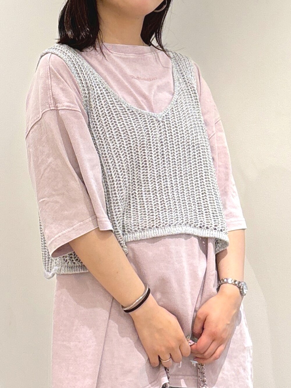 シルバー系のベスト、ピンク系のTシャツ/カットソー、ブルー系のデニムパンツを着用したレディースの夏コーディネートの4枚目の写真