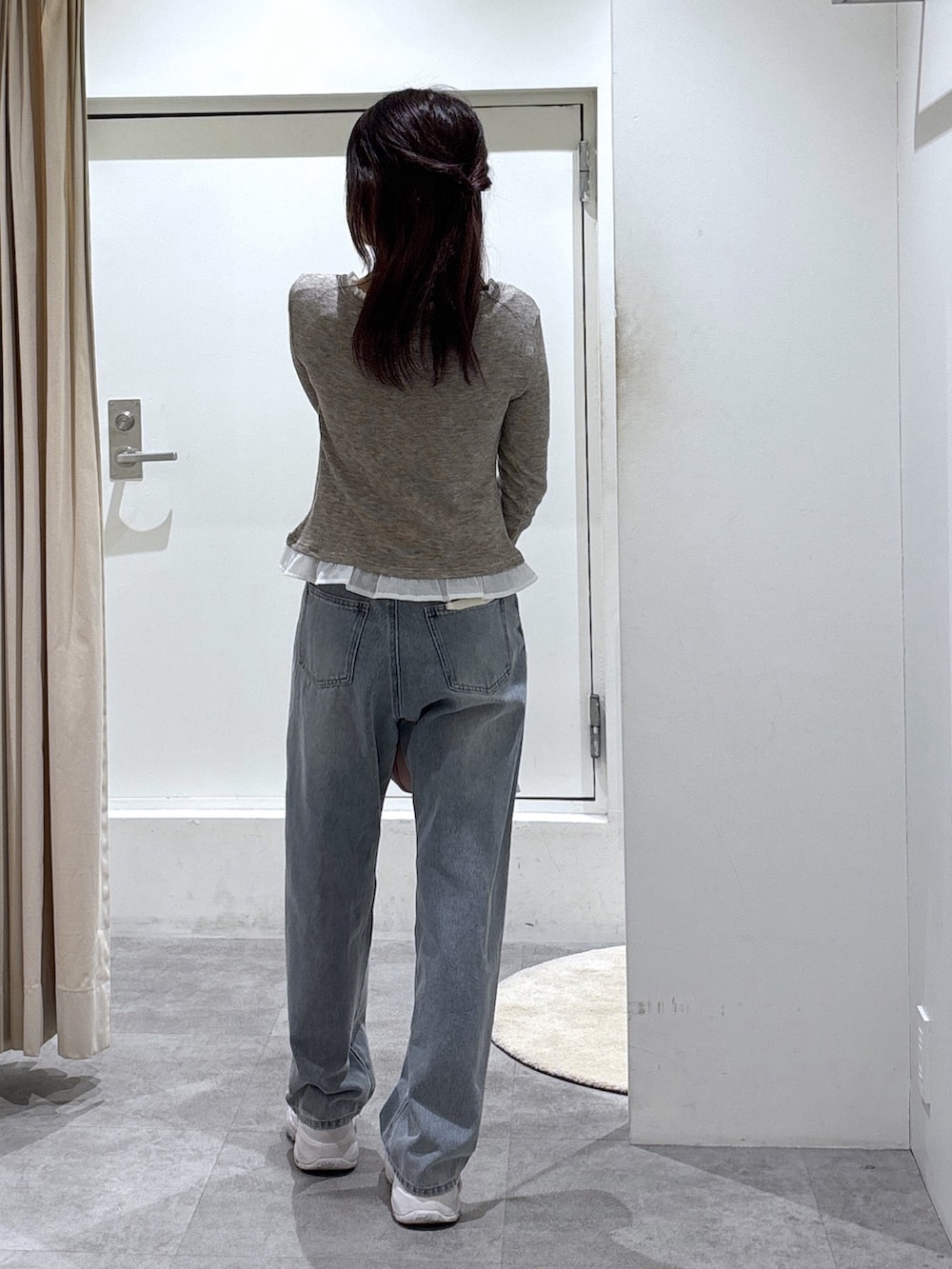 ブラウン系のTシャツ/カットソー、ブルー系のデニムパンツ、ピンク系のボストンバッグを着用したレディースの冬コーディネートの3枚目の写真