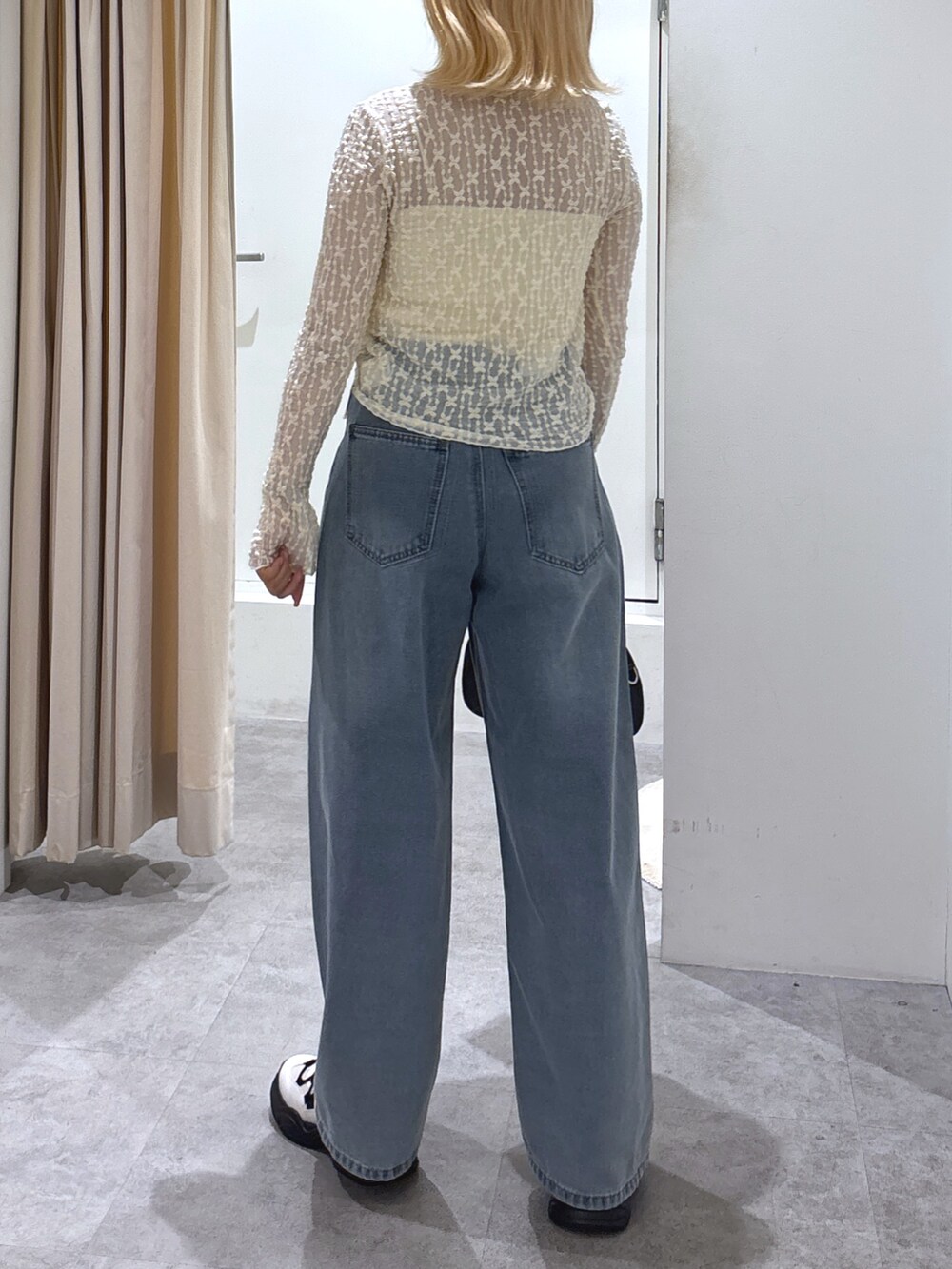 ホワイト系のカーディガン/ボレロ、ブルー系のデニムパンツ、ホワイト系のスニーカーを着用したレディースの春コーディネートの5枚目の写真