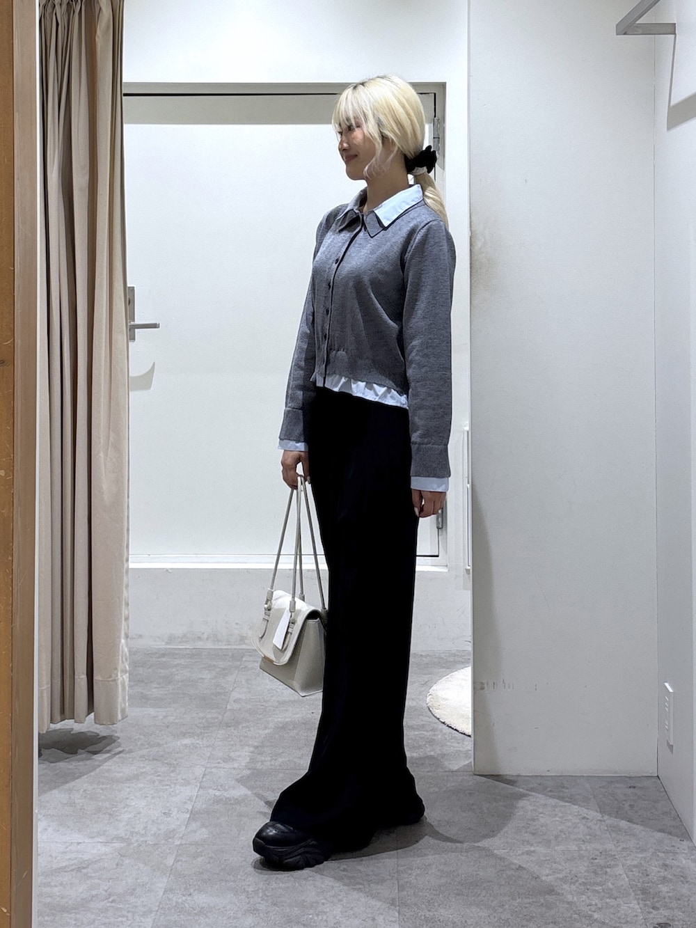 グレー系のニット/セーター、ブラック系のスラックスを着用したレディースの冬コーディネートの2枚目の写真