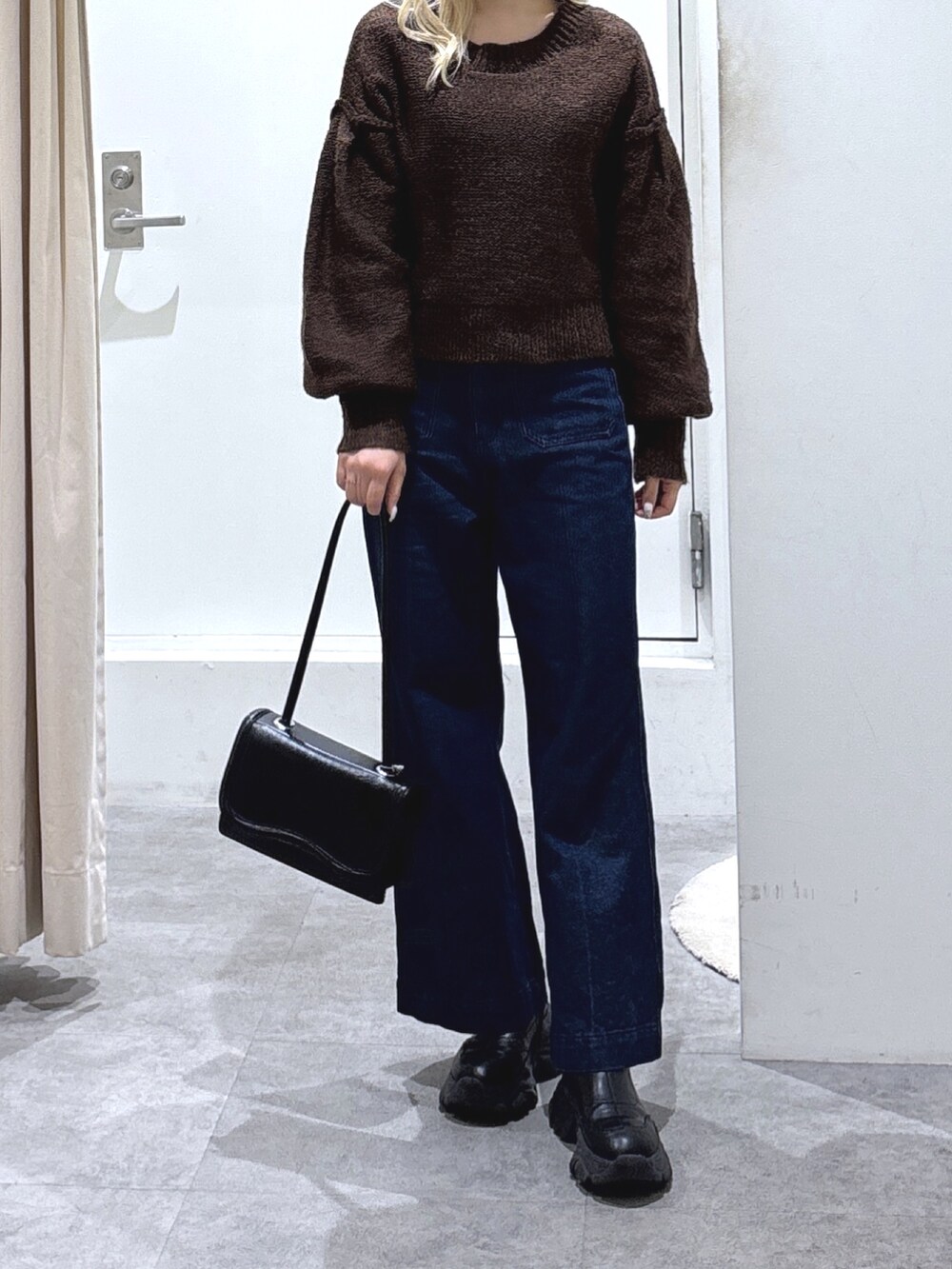 ブラウン系のニット/セーターを着用したレディースの冬コーディネートの2枚目の写真