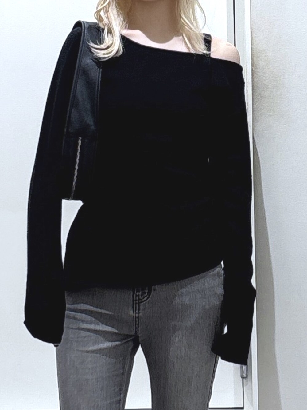 ブラック系のニット/セーター、ブラック系のデニムパンツを着用したレディースの秋コーディネートの2枚目の写真