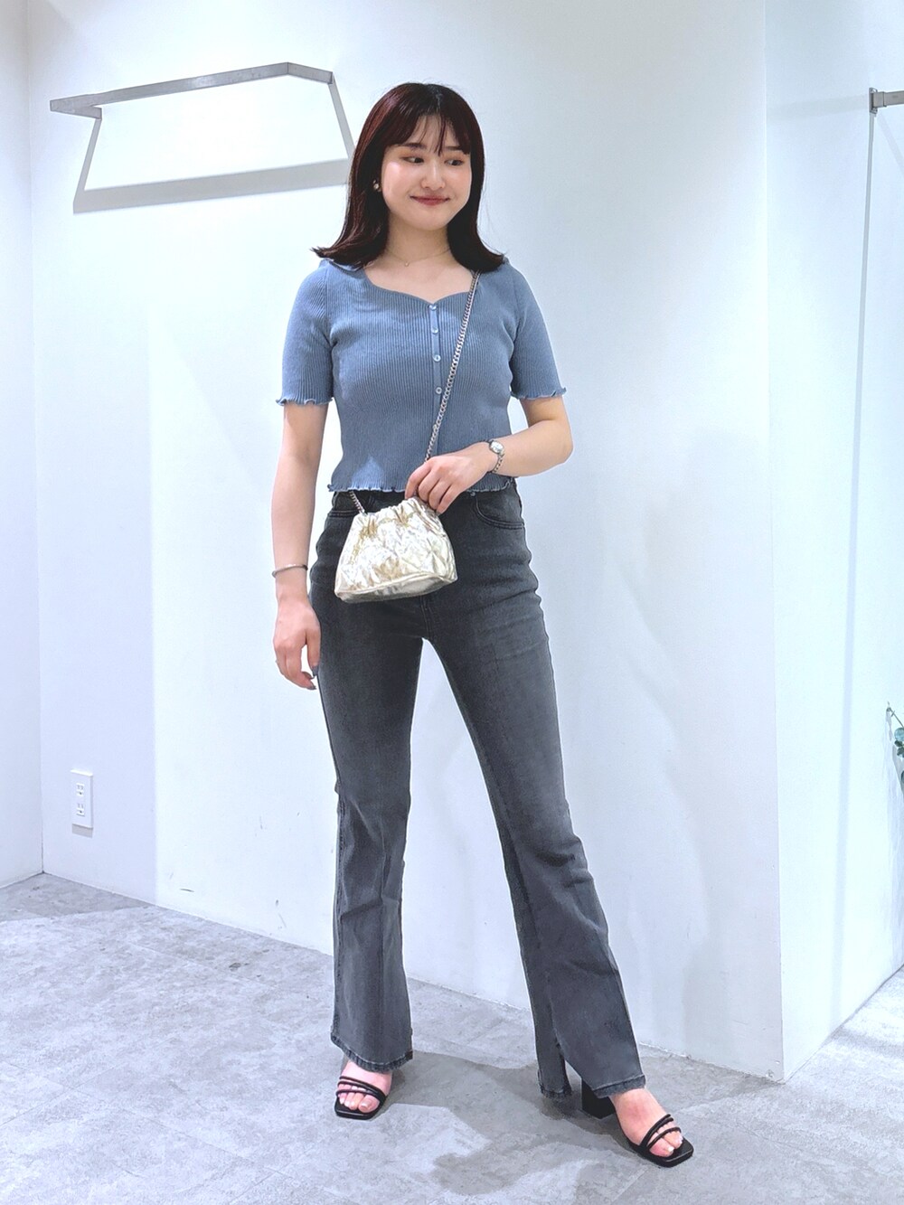 ブルー系のニット/セーター、ブラック系のデニムパンツ、ブラック系のサンダルを着用したレディースの夏コーディネートの2枚目の写真