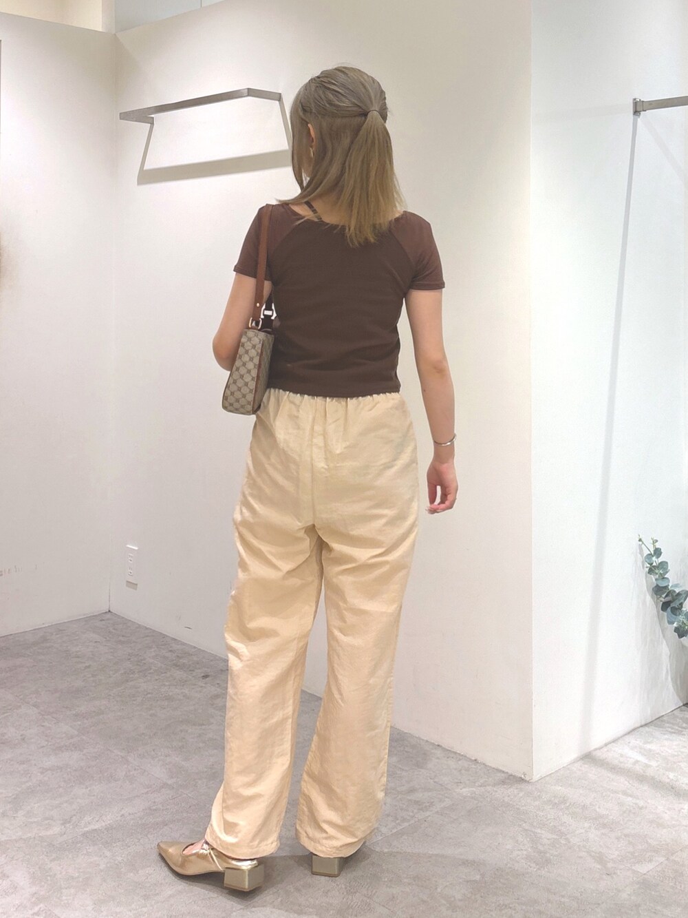 ブラウン系のTシャツ/カットソー、ベージュ系のショルダーバッグ、ゴールド系のパンプスを着用したレディースの夏コーディネートの4枚目の写真