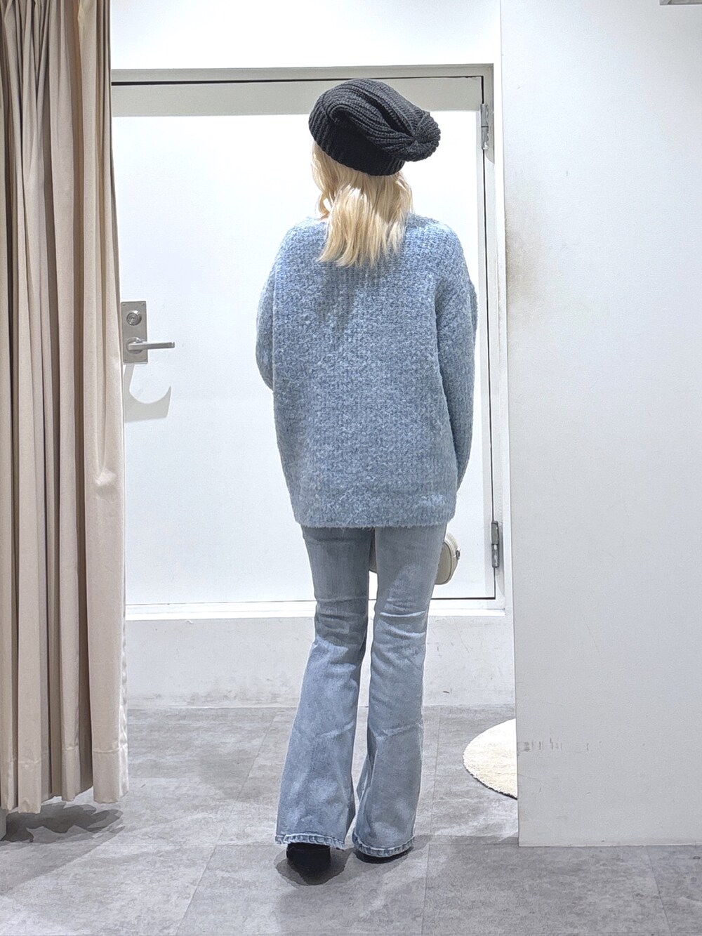 ブルー系のニット/セーター、ブルー系のデニムパンツを着用したレディースの秋コーディネートの3枚目の写真
