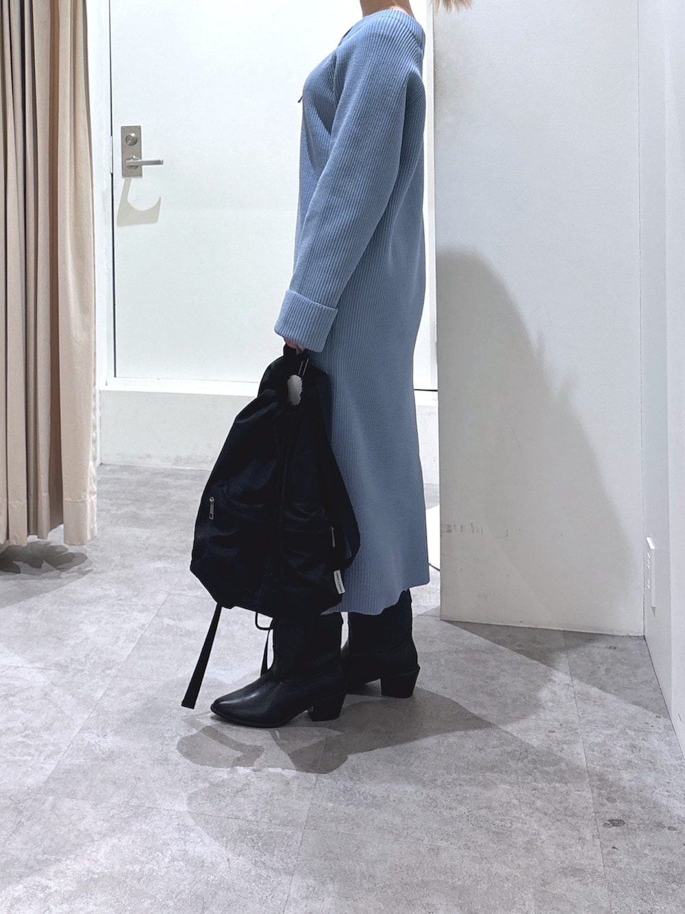 ブルー系のワンピース、ブラック系のブーツを着用したレディースの冬コーディネートの4枚目の写真