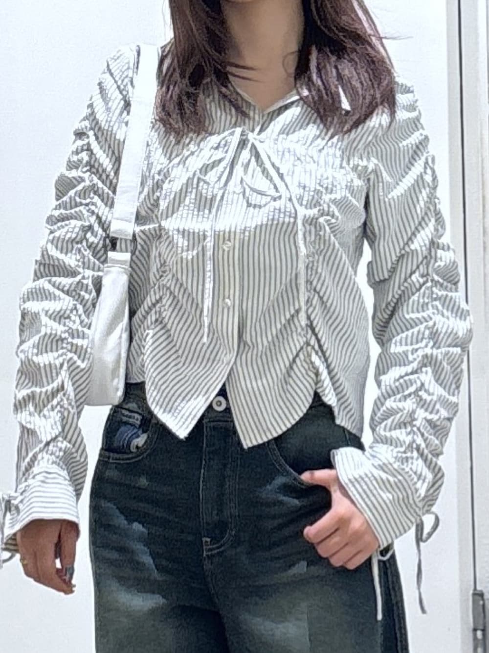 ホワイト系のシャツ/ブラウス、ブルー系のデニムパンツを着用したレディースの冬コーディネートの2枚目の写真