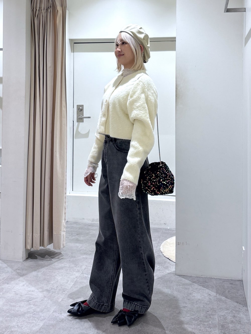 ホワイト系のニット/セーター、ブラック系のデニムパンツ、ホワイト系のTシャツ/カットソーを着用したレディースの冬コーディネートの3枚目の写真