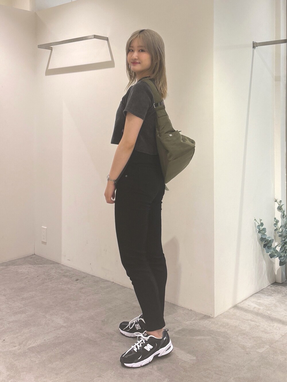 ブラック系のTシャツ/カットソー、ブラック系のデニムパンツ、グリーン系のショルダーバッグを着用したレディースの夏コーディネートの2枚目の写真