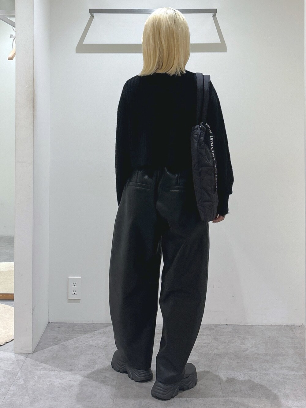 ブラック系のニット/セーター、ブラック系のその他パンツ、ブラック系のトートバッグを着用したレディースの秋コーディネートの4枚目の写真