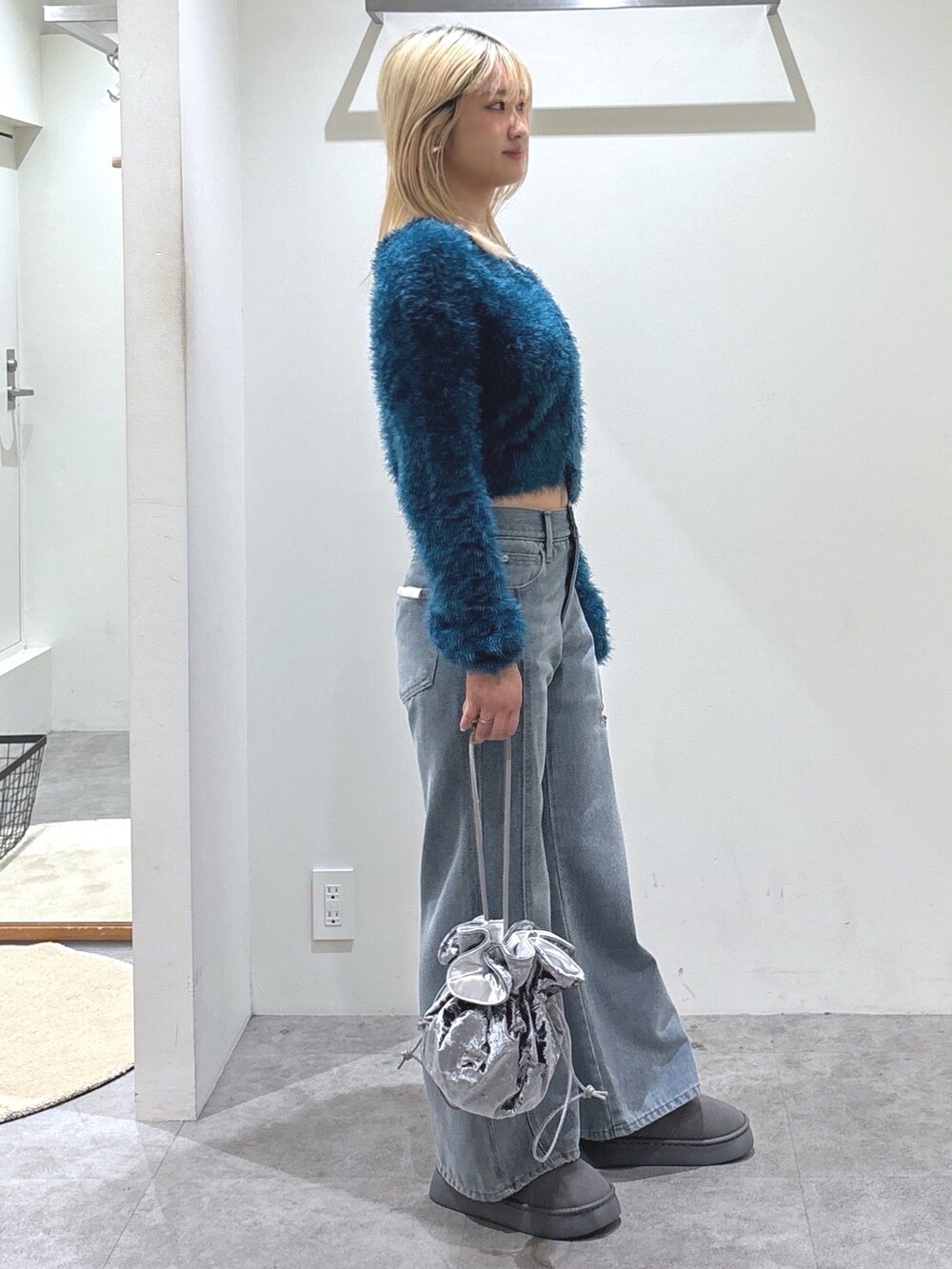 ブルー系のデニムパンツ、グレー系のブーツ、ブルー系のカーディガン/ボレロを着用したレディースの秋コーディネートの2枚目の写真