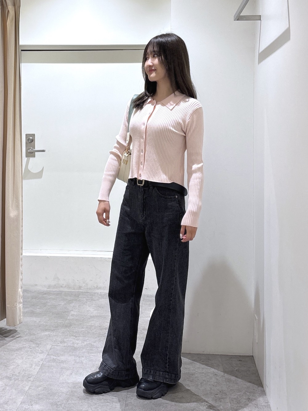 ピンク系のニット/セーター、ブラック系のデニムパンツを着用したレディースの冬コーディネートの3枚目の写真